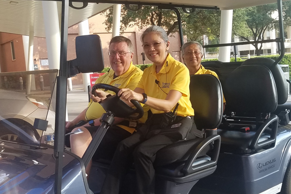 Hobby Center employees driving a golf cart