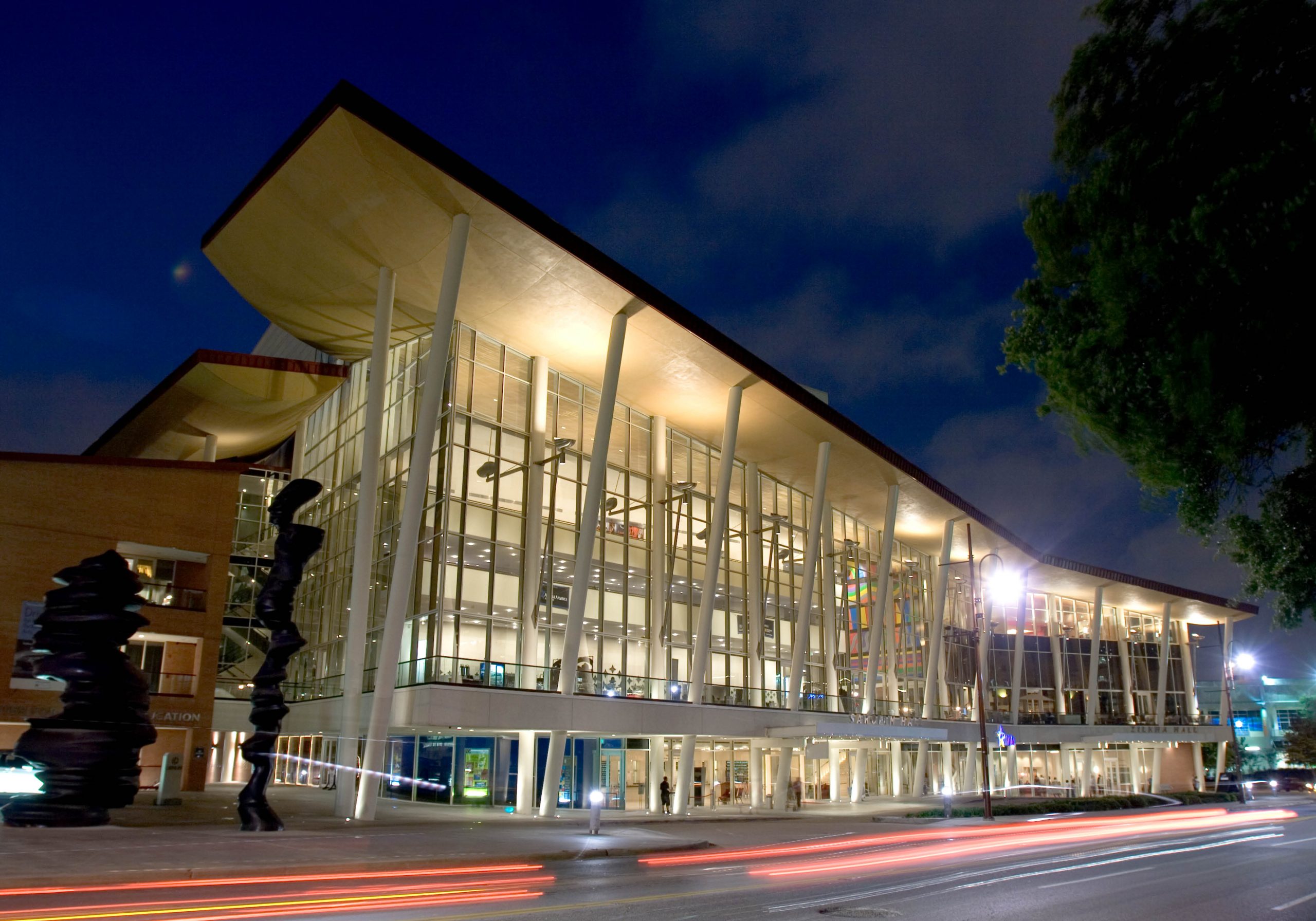 View of the Hobby Center building in evening with the exterior lights illuminating the windows