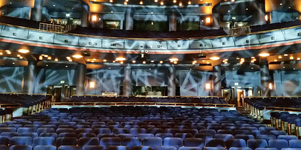 Beautiful depiction of the lights beaming on the blue seats of Sarofim Hall