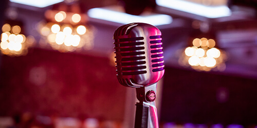 Retro microphone with pink and red mood lighting featured in a lounge